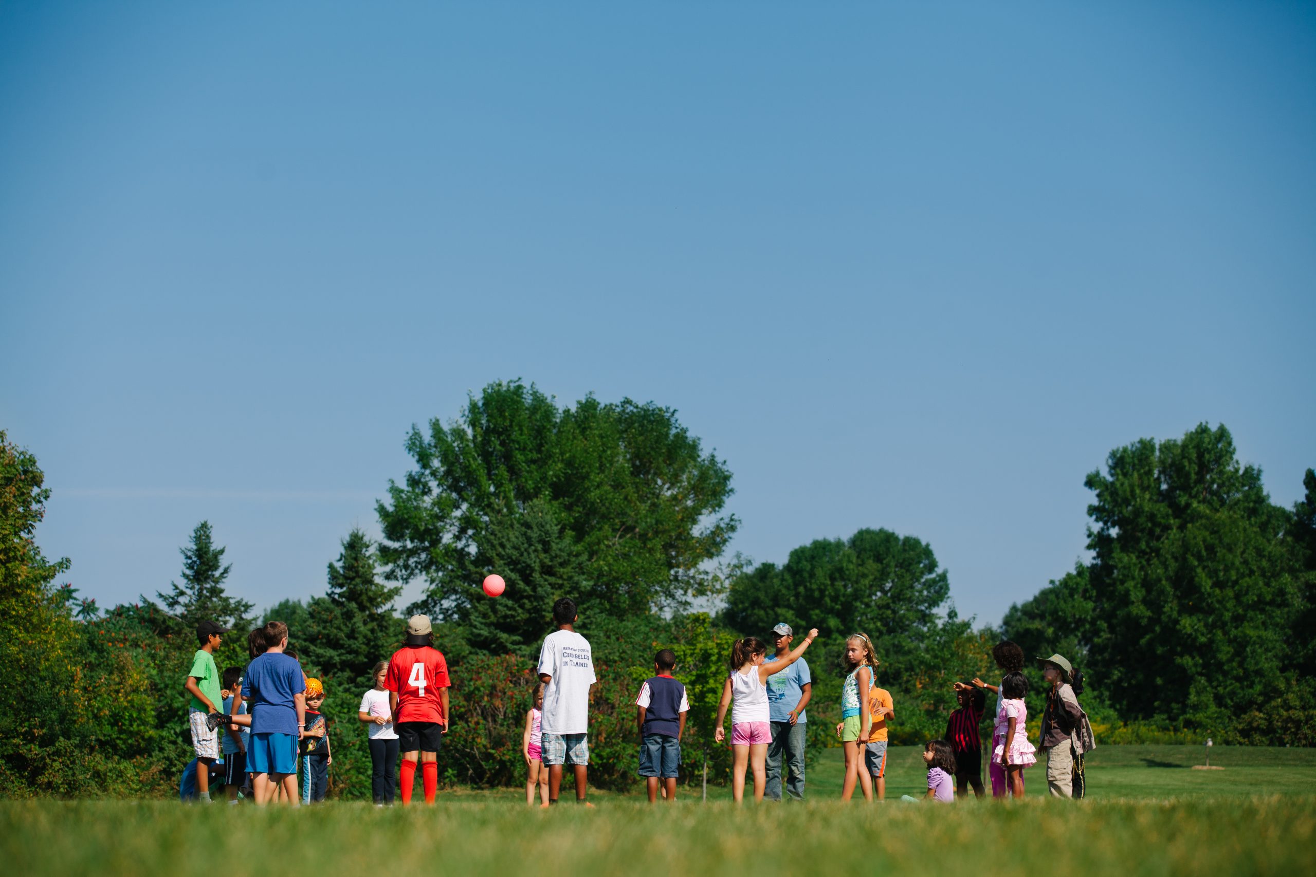 group of kids standing in a circle playing at park