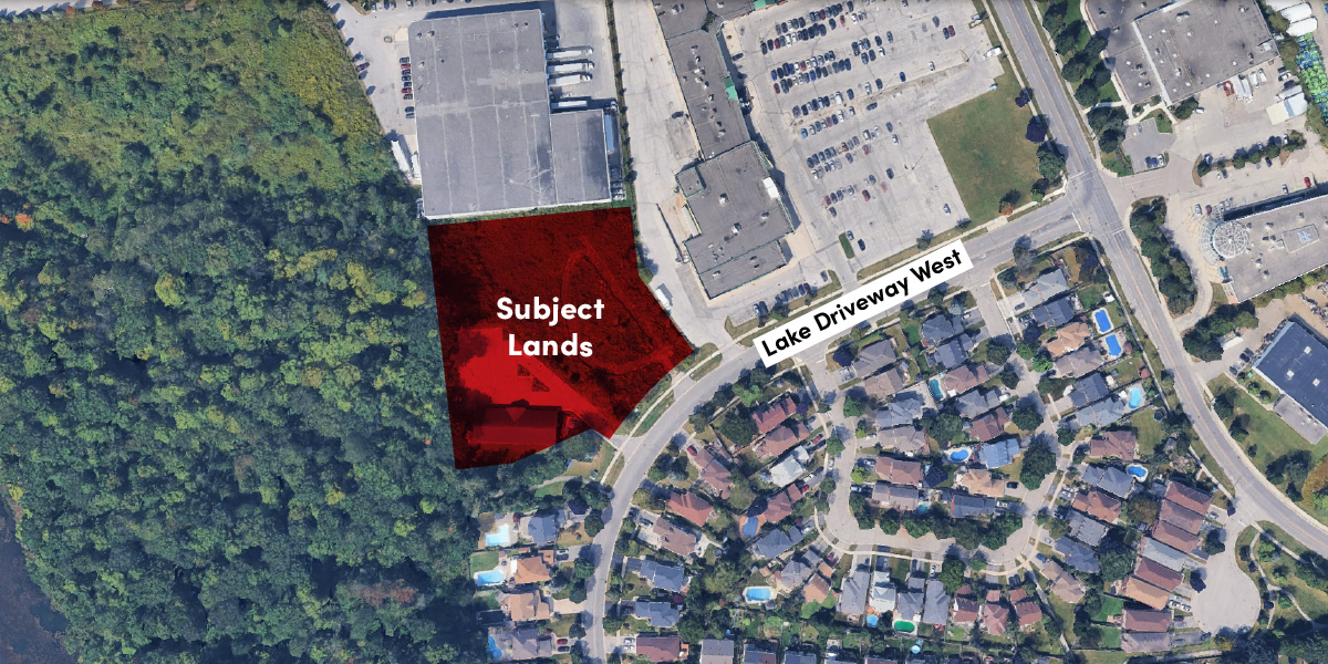Aerial view highlighting "Subject Lands" near Lake Driveway West, adjacent to a wooded area, car park, and residential homes.