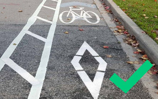 Cycle lane with painted markings and a green tick symbol on the right side of the image.