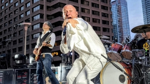 Frontman of the band The Hip Experience, sings on stage and points at the camera.