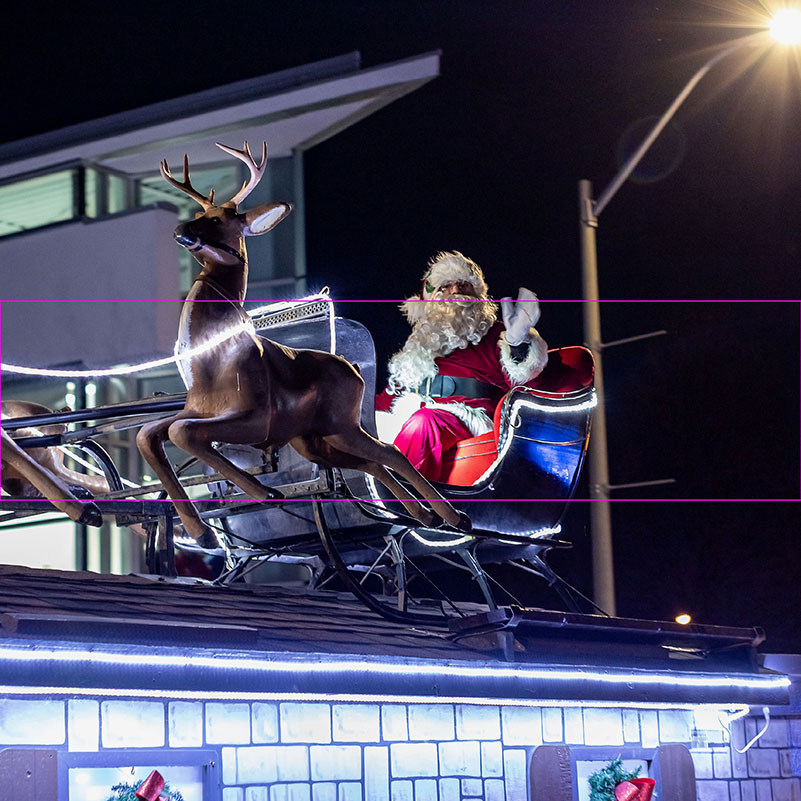 Santa waves at the crowd from his float in Santa's Spectacle of Lights.