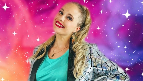 Magic Mel stands in front of a colourful starry background.