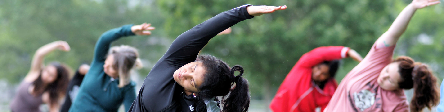 A group of people participate in Sunset Yoga at the Ajax waterfront.