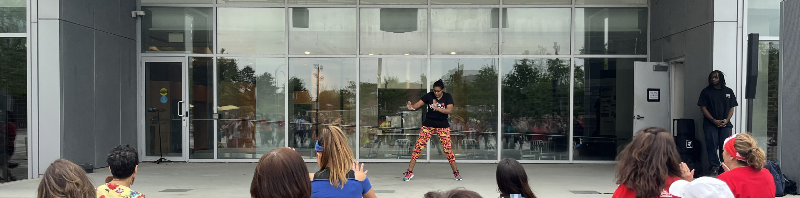A fitness instructor leads a group of people at Zumba® in the Square at Pat Bayly Square.