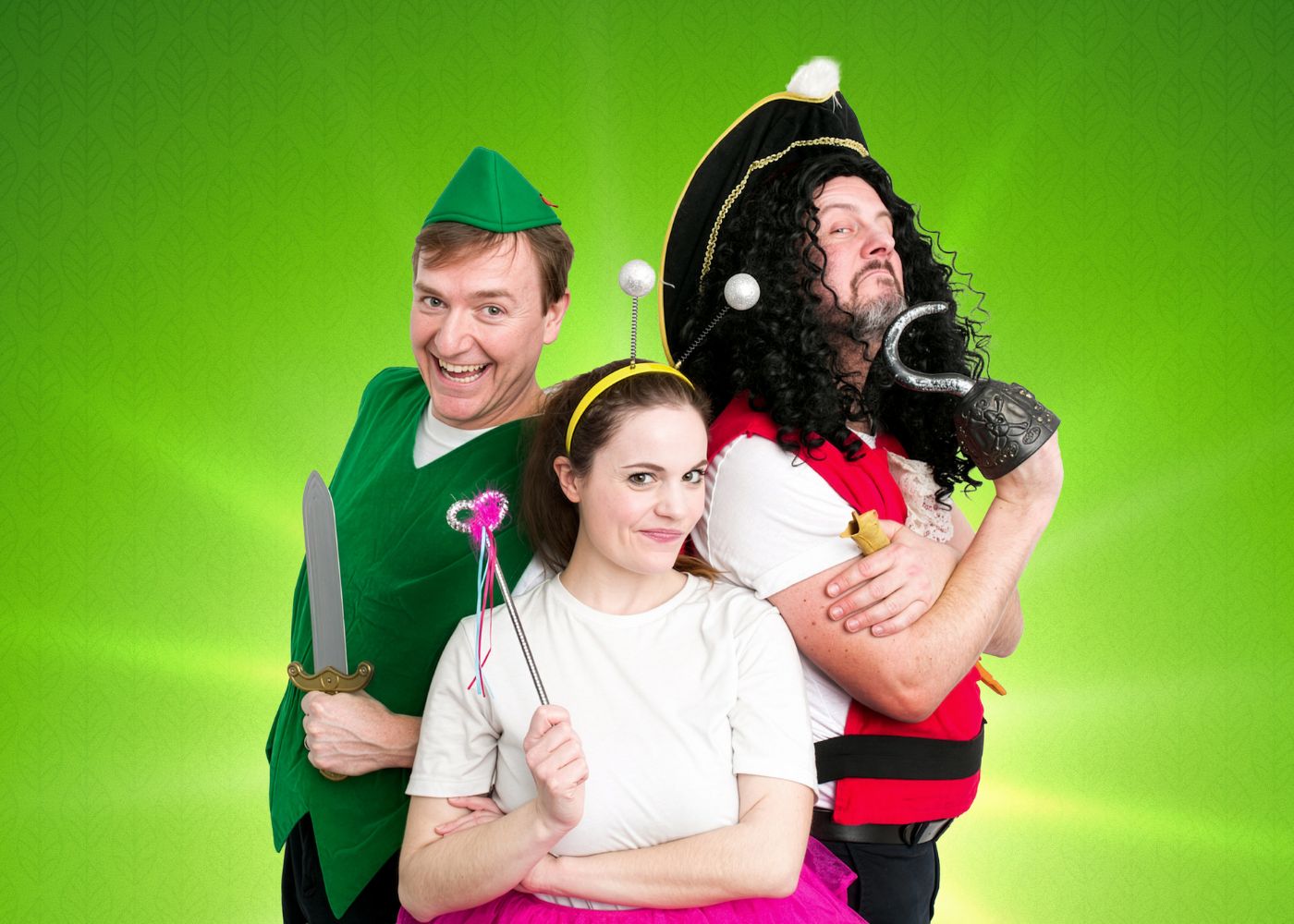Peter pan, Tinker Bell and Captain Hook pose together from a Peter Pan stage production against a bright green background