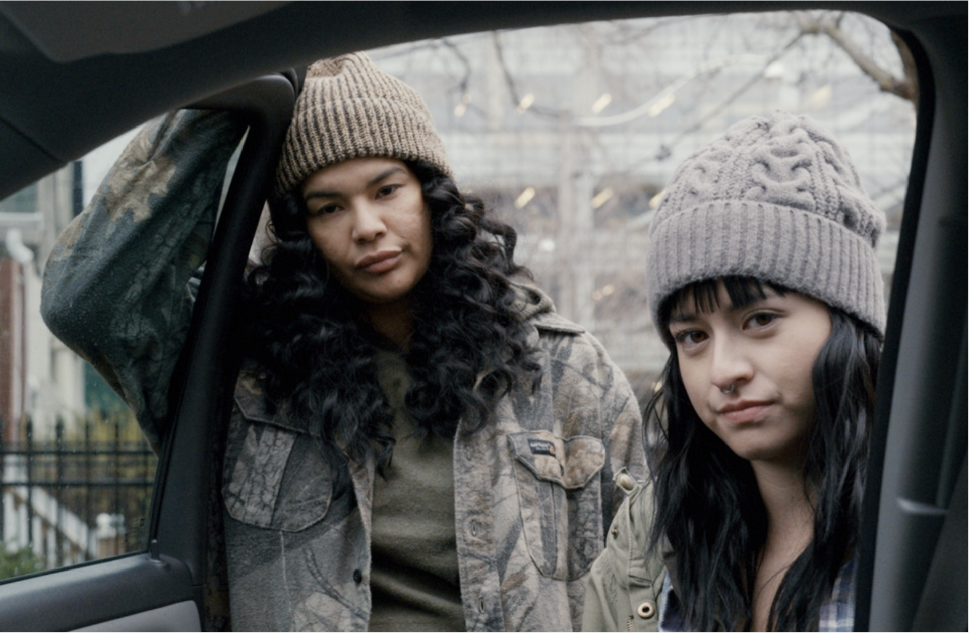 A car door open with two women looking inside.